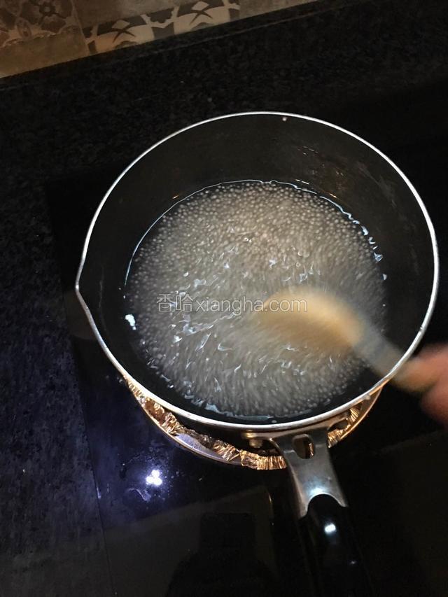 一边煮一边不停的搅拌，直到西米中只剩一点点白色，关火，盖上锅盖闷。如果发现水太少，一定要加开水！加完开水后搅拌一下，盖上锅盖闷。直到西米变成透明色！