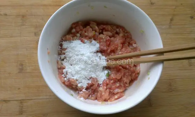 再放淀粉继续顺一个方向搅拌，准备小半碗清水，搅拌时，一点一点的加入，边加边搅，水不一定加完，看肉馅的粘稠度