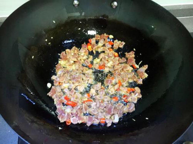 然后放入肉丁，迅速翻炒均匀。