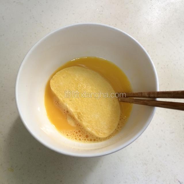 夹一块馒头片，把馒头片双面都沾上鸡蛋液。