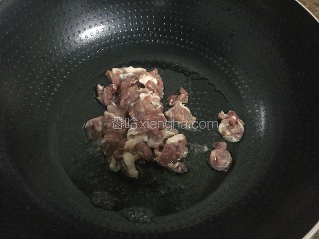 锅中倒入适量的油烧热后放入猪肉，炒至变色变白