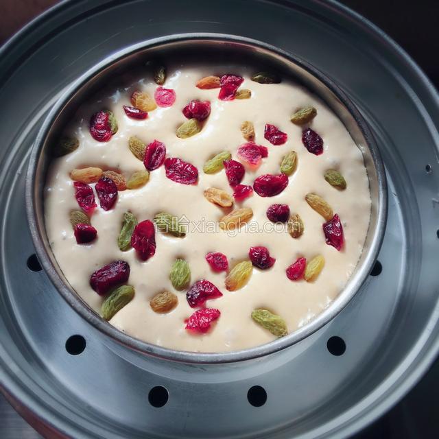 面糊发酵至两倍大的时候,一边撒上葡萄干,蔓越莓干。