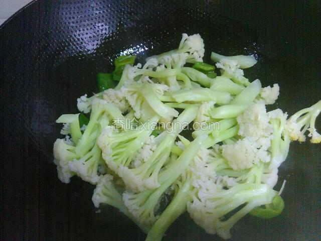接着倒入花菜炒匀