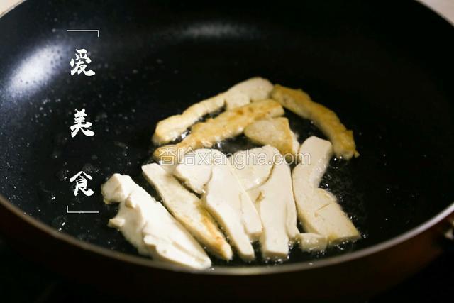 豆腐切片在油锅里两面煎黄，捞出切成丁