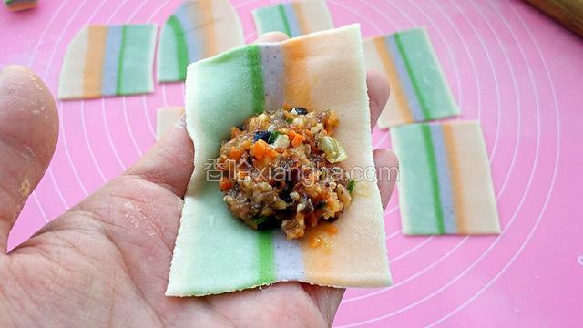 取一个馄饨皮，中间放上适量馅料。