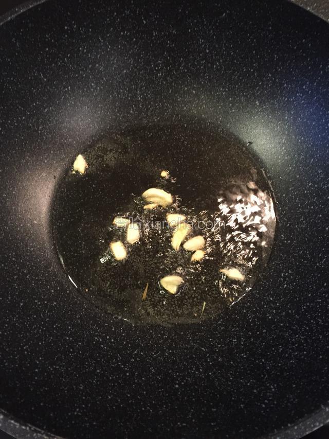 大火烧红煮锅将油烧热，放蒜末爆香。