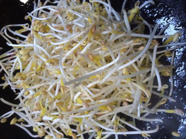 将豆芽倒入热油中翻炒片刻