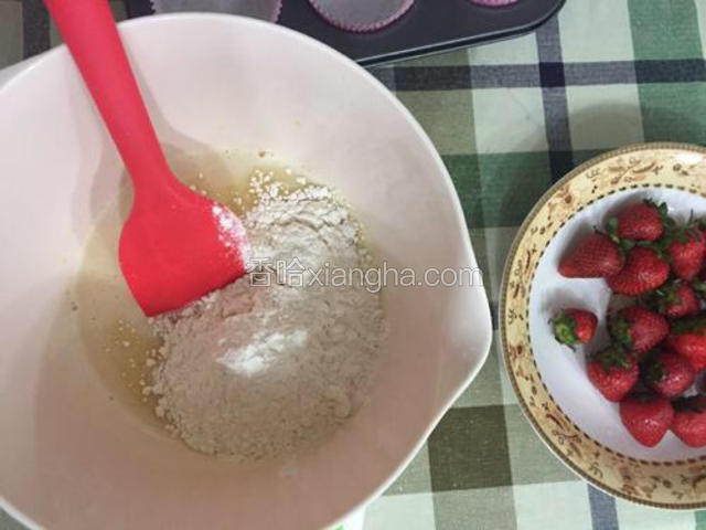 将过筛好的泡打粉和低筋面粉加入到液体中，以翻拌的手法搅拌至无干粉状态。