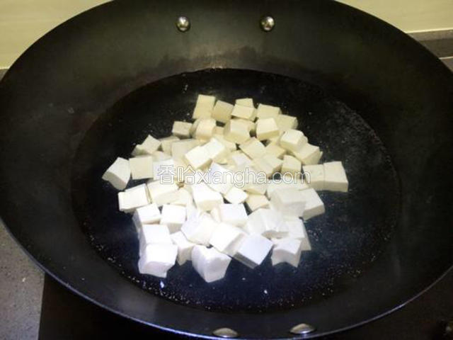 锅中加适量的水，水烧开后将豆腐放入锅中焯一分钟，然后捞出备用。