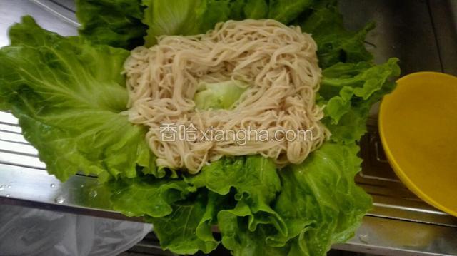 将拌好的面条摆在生菜上面