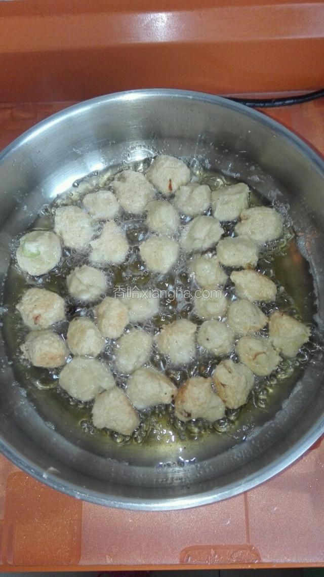 待小丸子定型后转中火慢慢炸，并用漏勺随时推动以免粘锅。