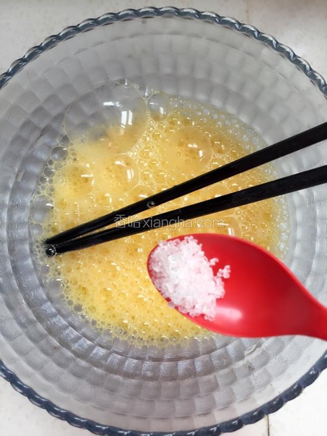 在打散的鸡蛋中加一点白砂糖。
