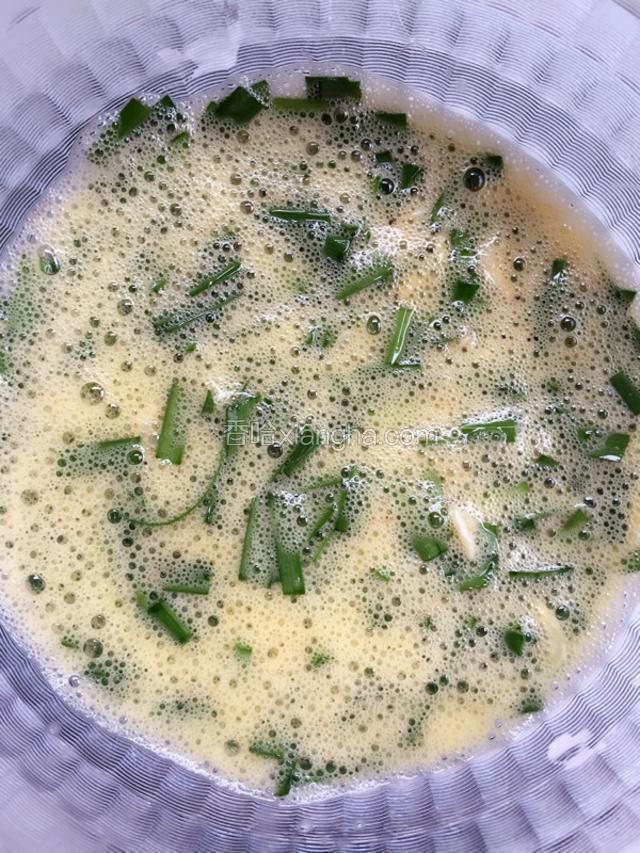 把虾皮和切好的韭菜放入鸡蛋液中搅匀。