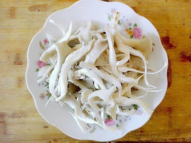 把蘑菇放水里清洗后，用手撕成小朵，然后放盘子里备用。
