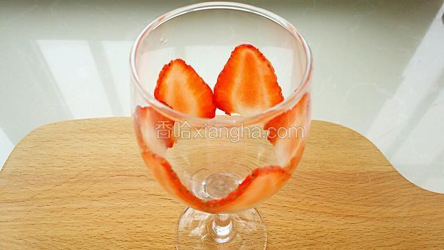 取一个干净玻璃杯，把草莓片贴到玻璃杯里。