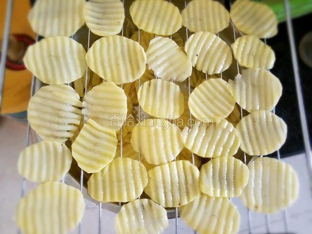 把土豆片铺在烤网或烤盘上。