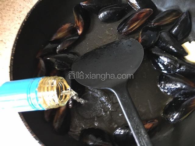 平底锅热放橄榄油，把一粒蒜拍碎放入锅中煸炒。放入洗净的贻贝煸炒。放入一点点盐。倒入白葡萄酒。盖上锅盖煮3分钟。煮好后留6-8个带壳的贻贝。不剥离贝肉。其余剥离贝肉。连汤备用。另一锅沸水加盐按说明时间煮意面。