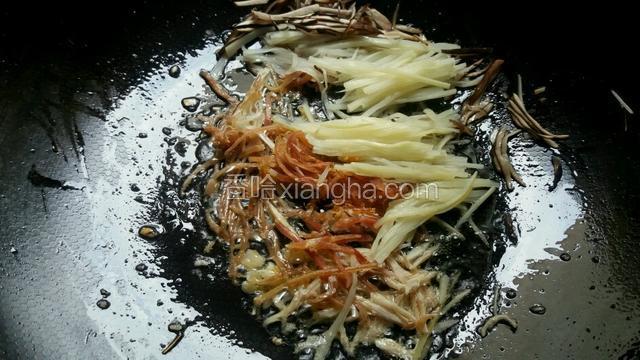 依次放入火腿丝，冬笋丝，香菇丝和鸡丝略为煸炒。