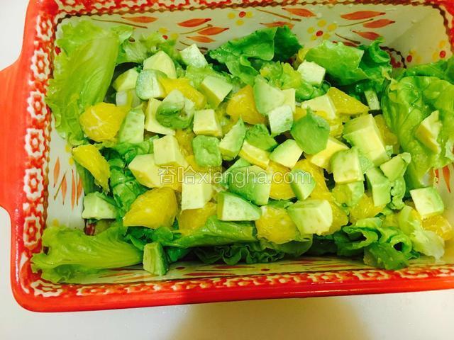 将牛油果块和橙肉块均匀铺在生菜上