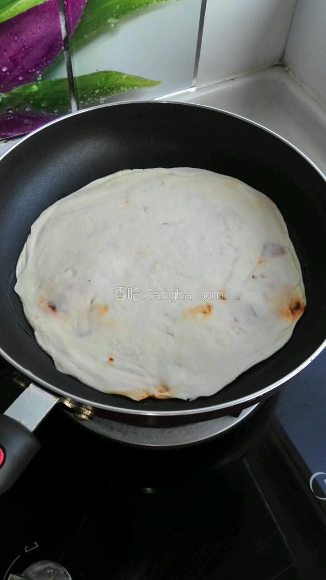 放入大饼，小火开始烙。