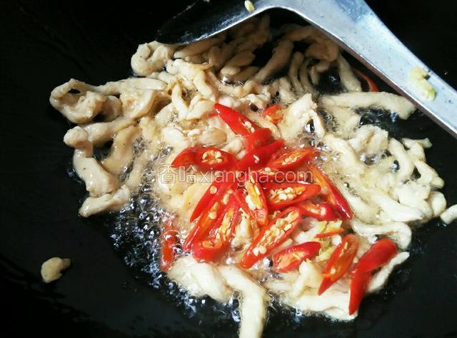 倒入鸡肉快速翻炒；炒至肉变色，放入小米椒和姜爆香