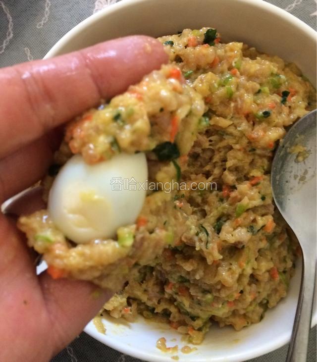 取适量肉馅儿摊开，放入鹌鹑蛋