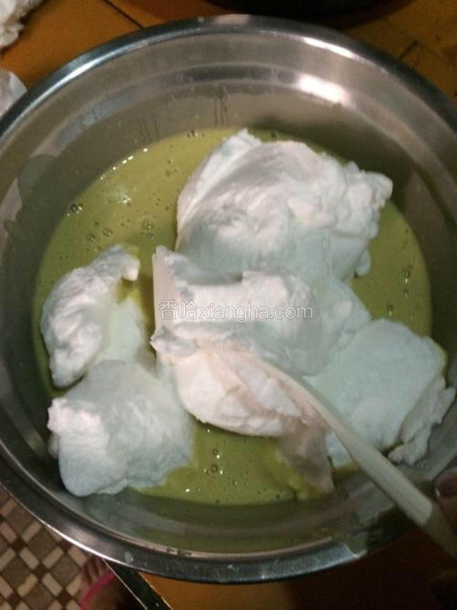 下面把刚刚搅拌好的蛋黄拿出来 把蛋清分三次加入到蛋黄中 注意 这时就不可以打圈搅拌了 只能上下左右均匀搅拌 像海底捞月般 转圈搅拌会把蛋清的气泡打破 那样蛋糕就不能发大了 