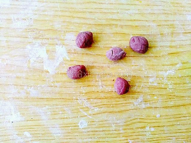 在取红色的面，搓成小面团做小花