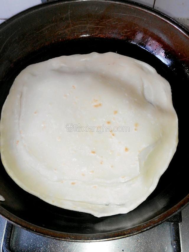 等饼看起来变色，翻面烙制，看到饼有蓬松分层掀起，即可取出。