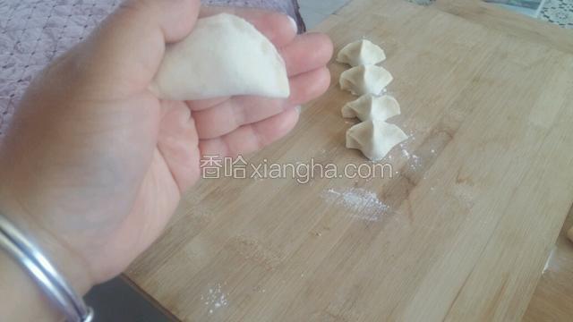 两手这样捏着饺子，使劲向里挤，饺子就包成了。