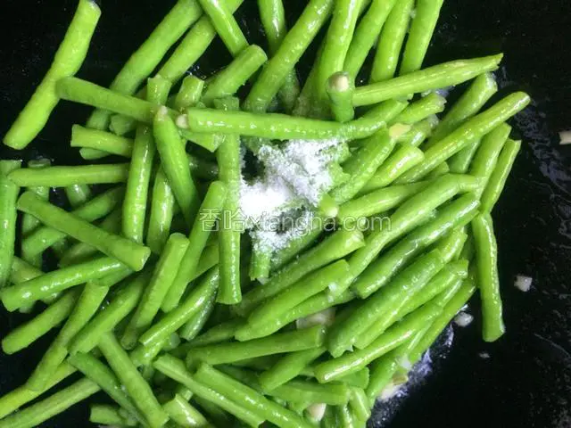 炒至快断生，倒入适量的盐和少量的水，将豆子焖煮片刻