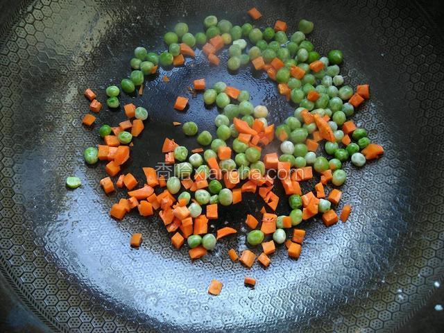 将鸡蛋碎取出，倒入豌豆粒和胡萝卜丁。