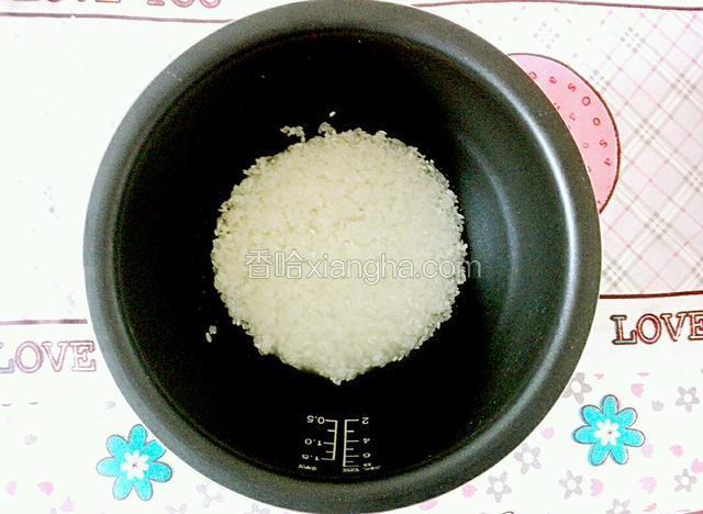 给电饭煲内胆里放入大米，然后加入适量的开水。