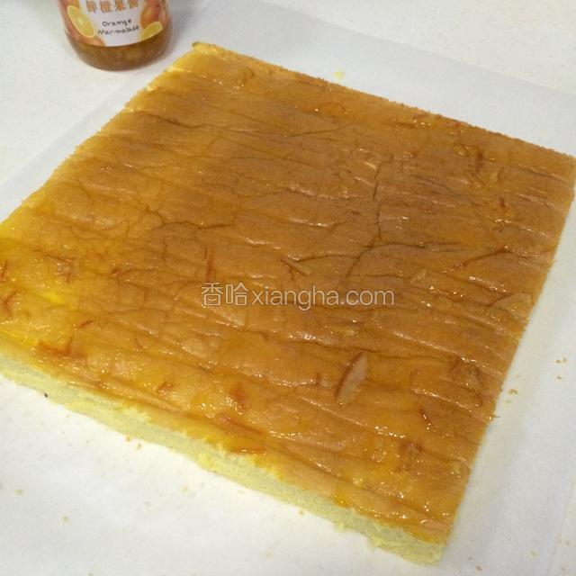 稍凉后，反扣在干净的油纸上；切掉蛋糕边，均匀的涂抹上果酱；