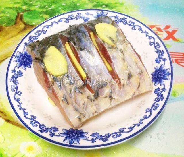 放入腌好的鱼段,在鱼缝、鱼背中放入姜片,淋入少许料酒.