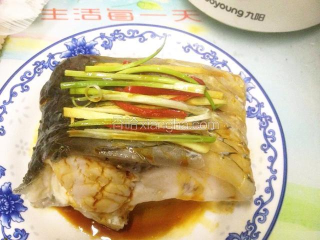 去掉蒸鱼段盘上的水,去掉姜片,在鱼段上码入姜、葱、小米椒丝,淋入蒸鱼鼓油.