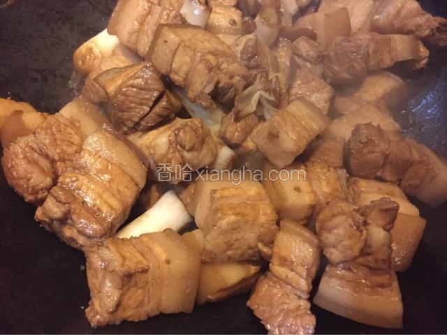如图热锅冷油，油热加入葱段，姜丝，八角炒香如图倒入处理好的五花肉，淋入酱油翻炒片刻