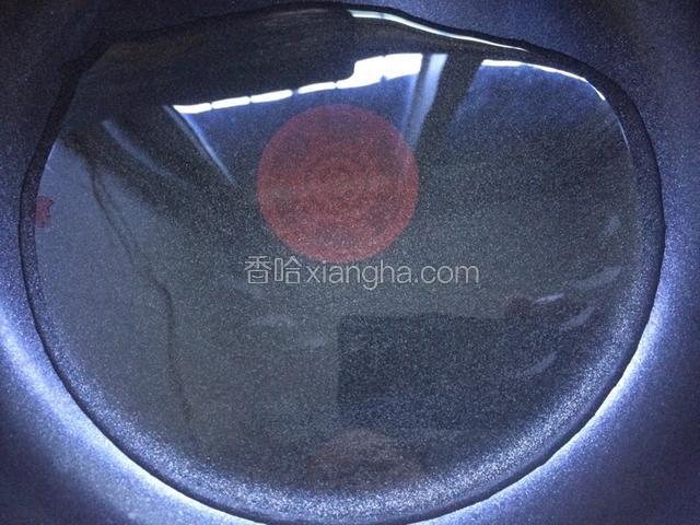 将不粘锅洗净烧干，倒入适量的油，烧热至油温200度左右