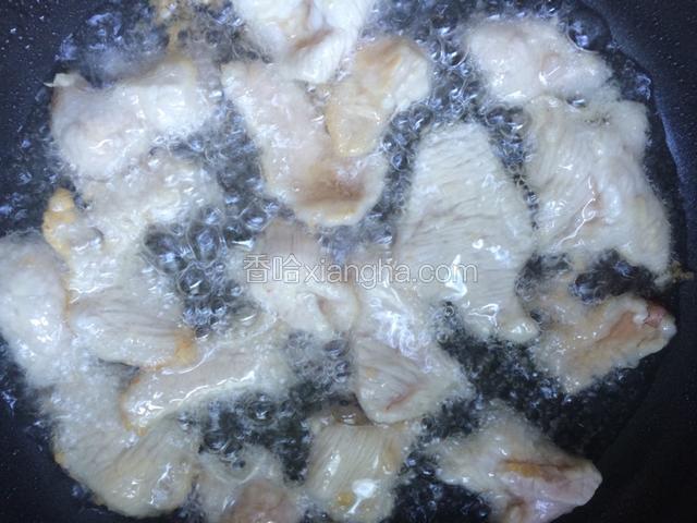 将粘有水淀粉的瘦肉片用筷子夹着一一放入热油中，炸至断生即可捞出，余下的油留作它用