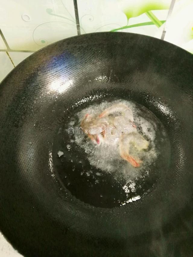 锅中下油 油烧至七成热下入腌制好的虾  虾全部变色后捞出