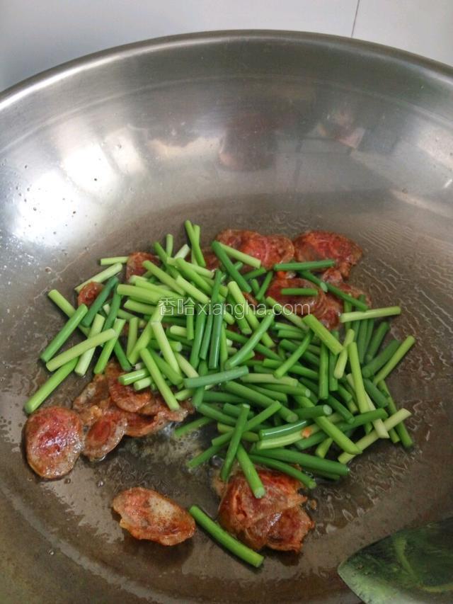 热锅凉油下锅， 放腊肠爆炒出油放入蒜苗，炒至蒜苗微软