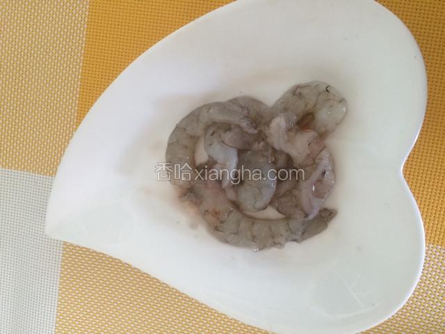 将虾去皮挑虾线，放入盘中倒入料酒，少放一点点盐，腌制备用。