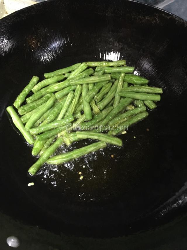 倒入豆角煎熟到虎皮状就好了，这个时候如果觉得油多可以倒出来一部分把豆角拨到一边