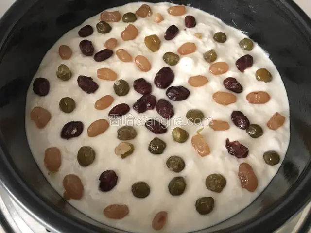 再倒入另外一半面糊，抹平，端起蛋糕膜，摔几下，在排出里面的气泡，上面撒一些蜜豆；