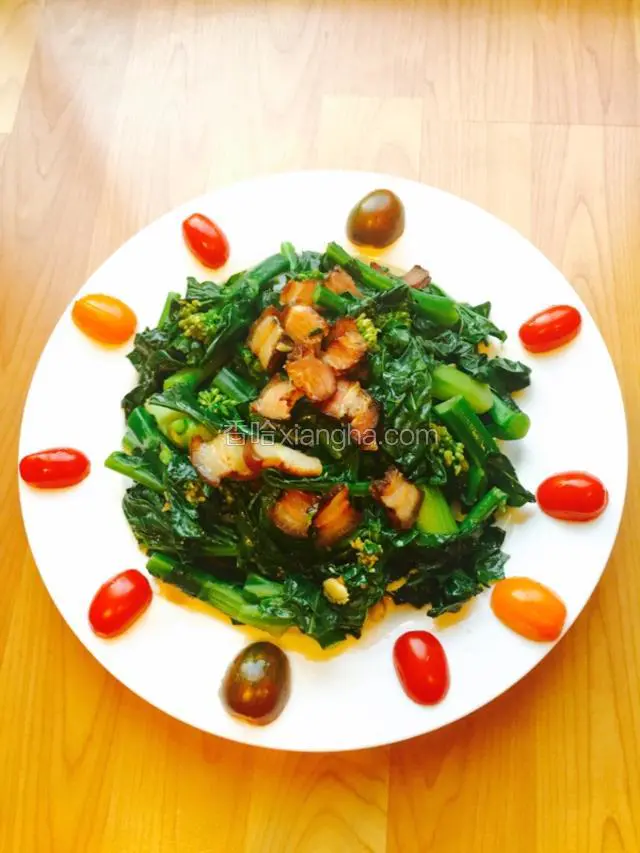 碟爽脆腊肉香味的芥兰菜完成再用圣女果做装饰就很漂亮。