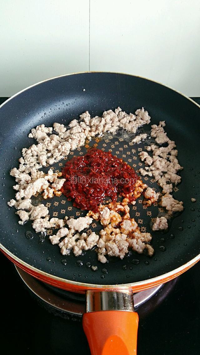 肉末铲至锅边，倒入豆瓣酱小火煸出红油。