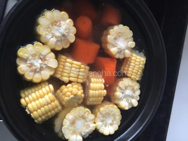 洗好后把洗净改好刀的玉米和胡萝卜块一起倒入沙锅中煮 