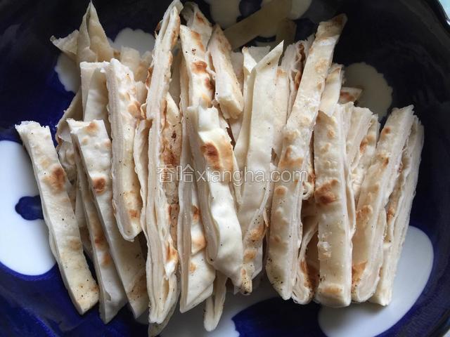 将饼切成稍微宽一点的饼丝备用，比炒饼用的饼丝略宽一点，这样烩饼的时候不会烂掉。