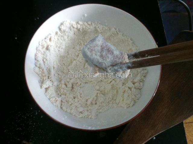 锅中油烧六七热，把肉裹上一层面粉。