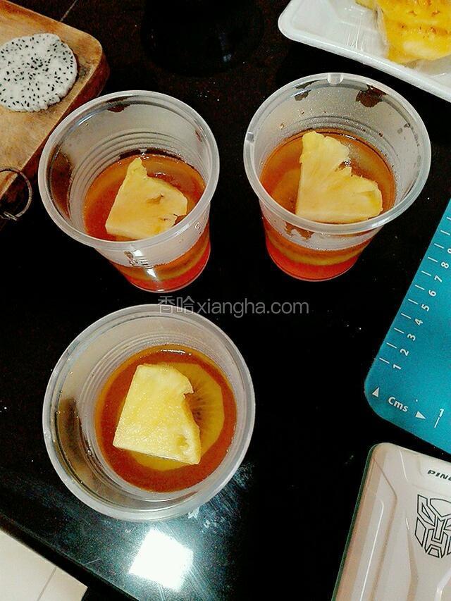 从冰箱中取出冻好的两层布丁，在上面放上一片菠萝